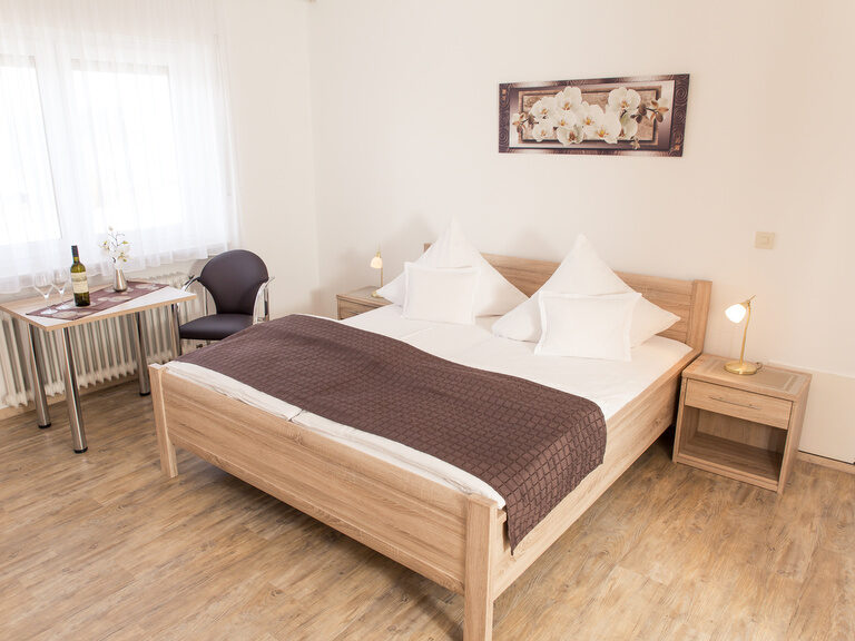 In einem Zimmer im Hohenauer Hof ist ein hölzernes Doppelbett zu sehen